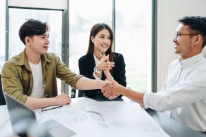 ทีมที่ปรึกษาการตลาด Top Reach Marketing กำลังพูดคุยและจับมือตกลงธุรกิจเกี่ยวกับการใช้กลยุทธ์ Product-Led Growth (PLG) เพื่อเปลี่ยนสินค้าให้เป็นเซลล์แมน