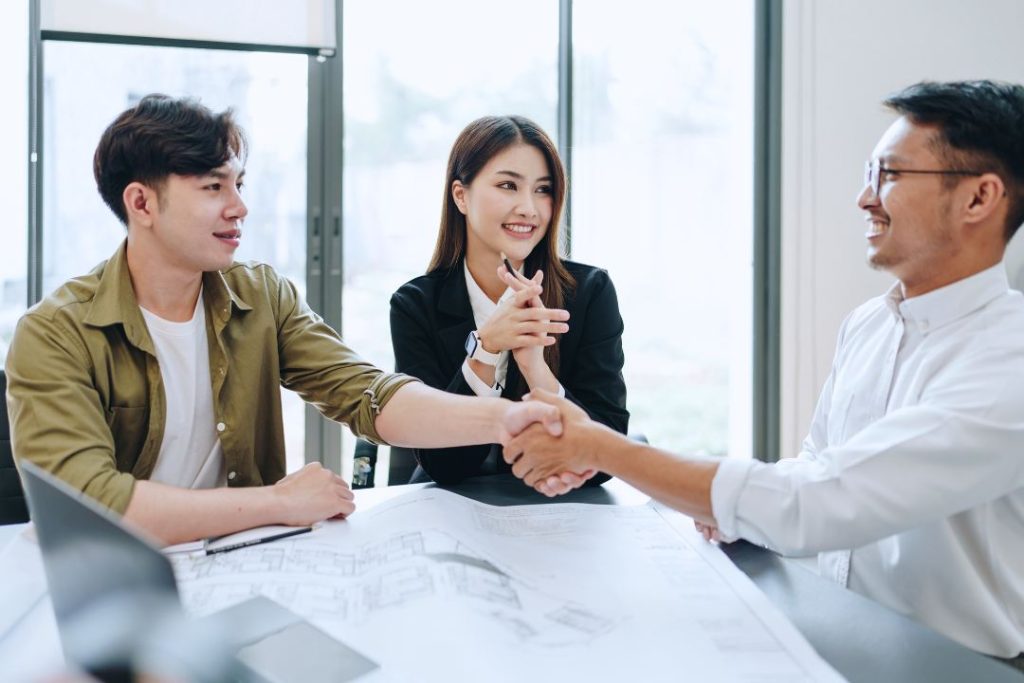 ผู้บริการแสดงความร่วมมือกับทีมการตลาด โดยมีทีมงานตบมือแสดงความยินดีด้านหลัง